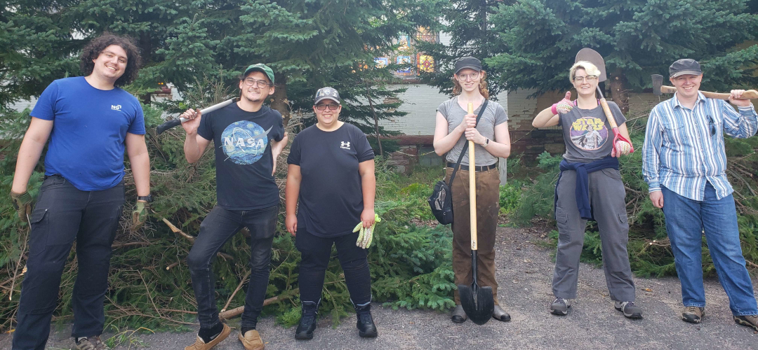 picture of several individuals posing with gardening equipment