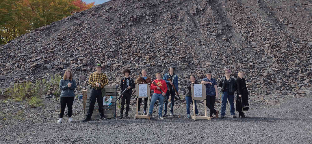 picture of a group of individuals holding firearms in a gravel pit